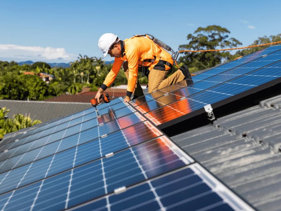 Technicien en train d'installer des panneaux solaires sur un toit